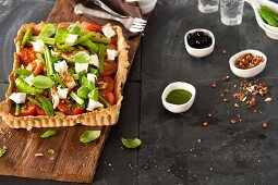 Tomato tart with cream cheese, herbs and lemon salsa on wooden board