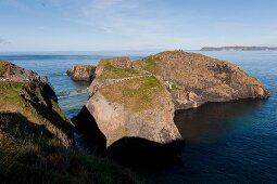 Irland: Antrim-Küste, Felsen, Meer, Carrick-a-Rede-Bridge, Wanderer.