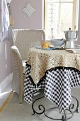 Round table with two super imposed table cloths in beige and black-white