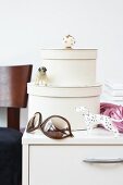 Beige boxes with furniture knob, dog figurines and sunglasses on side