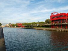 View of red buildings in Parc de la Villette beside Canal de l'Ourcq in Paris, France