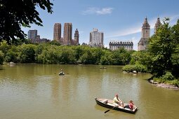 Couple on boat at Central park lake overlooking The Dakota, New York, USA