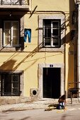 Girl playing on street of Alfama, Lisbon, Portugal