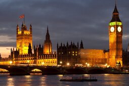 View of illuminated Palace of Westminster, Big Ben and river Thames, London, UK