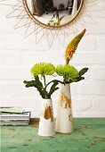 Green chrysanthemums with yellowish gold kniphofia in delicate vases