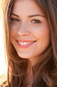 Portrait of beautiful woman with brown hair wearing orange top