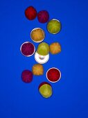Egg cups with colourful felt cap on blue background, overhead view