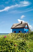 Facade of graswarder blue house on beach at Baltic Sea Coast, Germany