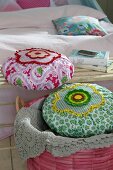 Close-up of fabric cushions decorated with crochet rosette in bucket