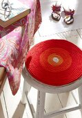 Red knitted stool cover on stool