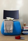 Blanket with book on blue and gray chair