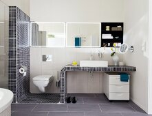 Washstand with mosaic tiles and toilet in bathroom