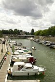 Boats moored in small harbour channel in Paris, France