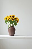 Vase mit Sonnenblumen steht auf dem Tisch