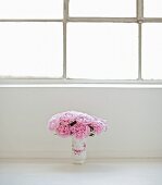 Bouquet of peonies in vase on floor
