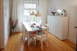 Dining area with wooden floor, sideboard and hanging lights