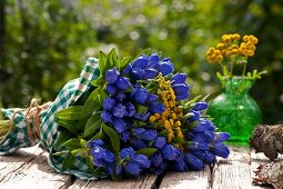 ein Blumenstrauß mit blauem Enzian und gelbem Rainfarn