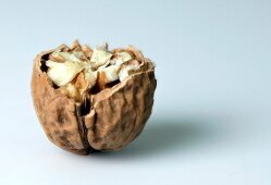 Close-up of walnut in broken shell on white background