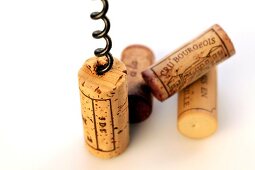 Wine cork with corkscrew on white background