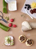 Ingredients for open sandwiches with quark and for cheese rolls with olives