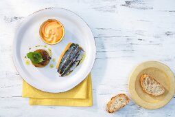 Sardines alimados with gazpacho jelly and pepper sauce on plate