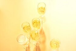 Glasses with champagne on yellow background