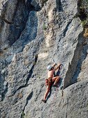 Man climbing rock mountain at Caletta Fuili, Cala Gonone, Sardinia, Italy