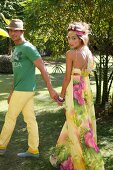 Couple wearing colourful summer outfit having fun in garden