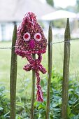 Pink hat with eyes and nose in garden