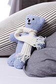 Blue knitted teddy with white scarf