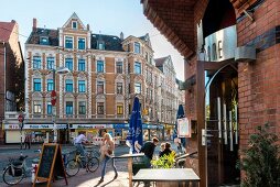 People sitting outside of Cafe Notre Dame in Linden, Hannover, Germany