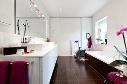 Vanity in bathroom with sink, tub and mirror