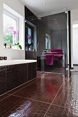 Bathroom with shower behind glass partition, bathtub & crocodile-skin-effect floor tiles