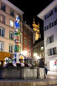 People sitting at sculpture near buildings in Lausanne, Canton of Vaud, Switzerland