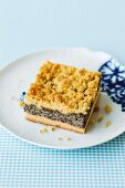 A slice of poppy seed crumble cake on a plate