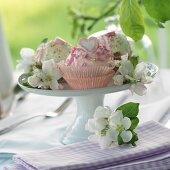 Various cakes decorated with apple blossom on a cake stand