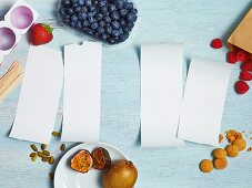 Four pieces of paper surrounded by ingredients for desserts