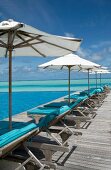 Parasol at swimming pool in front of sea, Dhigufinolhu island, Maldives