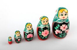 Five Russian dolls of various size on white background
