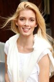 Portrait of beautiful blonde woman with long hair wearing purple top, smiling