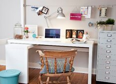 Corner table in bedroom with laptop, picture frame and table lamp