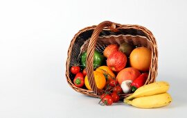 Basket of fruit and vegetables on white background