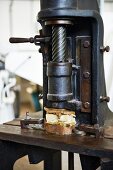 Close-up of svrew press being used for manufacture of soap