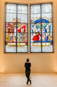 Woman standing in front of Kaiser window, Augustiner Museum, Freiburg, Germany