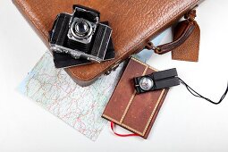 Diary, camera, briefcase and map for travel on white background