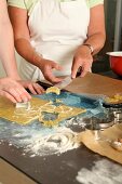 Person cutting moon shaped cookies with cutter