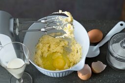 Sugar being added in mix baking ingredients in bowl for preparing waffle