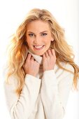 Portrait of beautiful blonde woman wearing white turtleneck sweater, smiling
