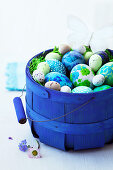 Easter eggs and butterflies in a blue basket