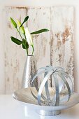 Kugel aus Blechstreifen in Silberschale, Lilien in Vase